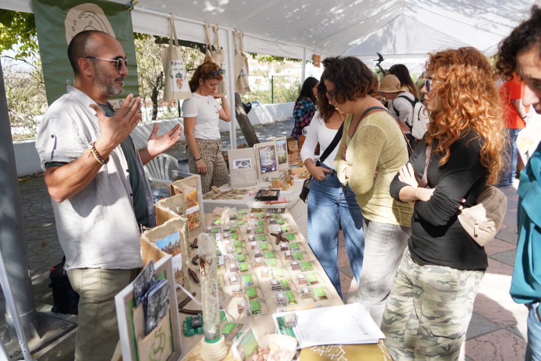 Público y entidades participantes en la feria medioambiental de Alpandeire